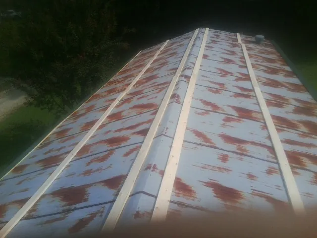 Rusted metal roof panels with new wood purlins before replacement — Storm Damage Roof Repair in Fort Ann by Roofing Brothers